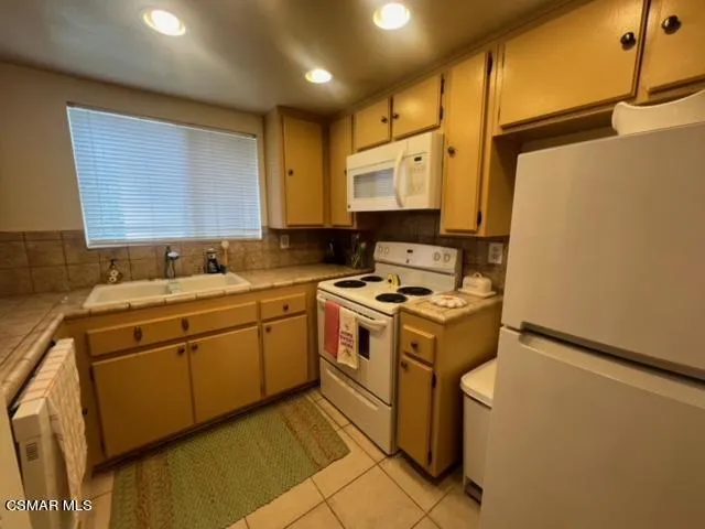 a kitchen with a sink appliances cabinets and a counter top space