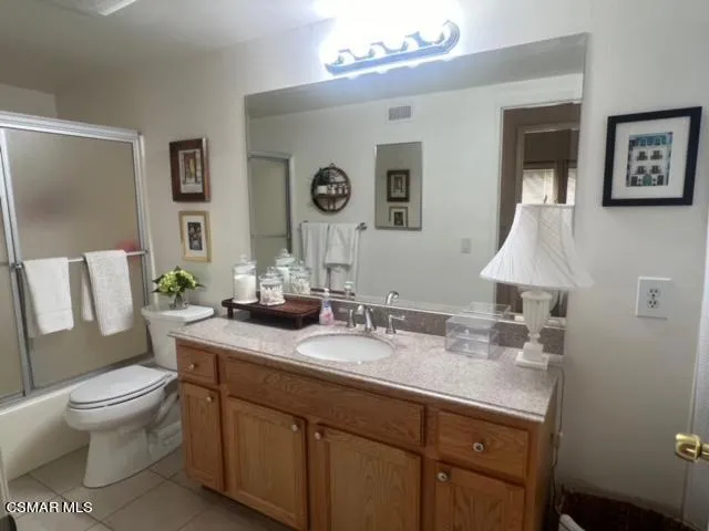 a bathroom with a granite countertop sink toilet and mirror