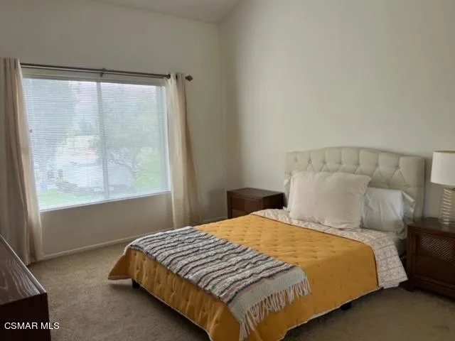 a large bed sitting in a bedroom next to a window