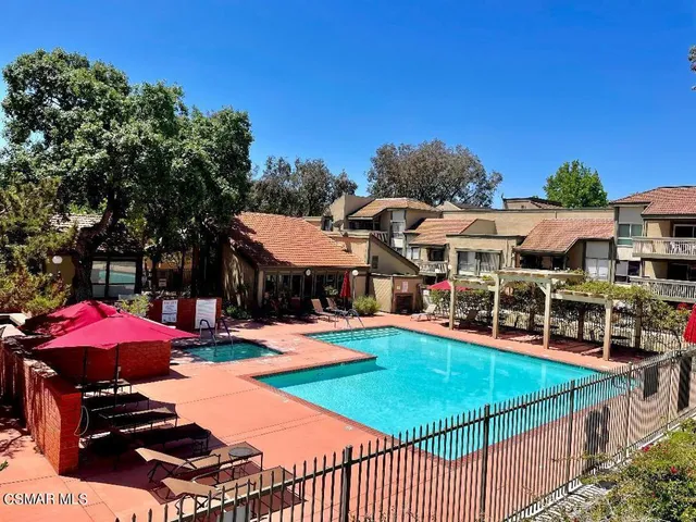 a view of a patio with chairs and umbrellas on a table and chairs