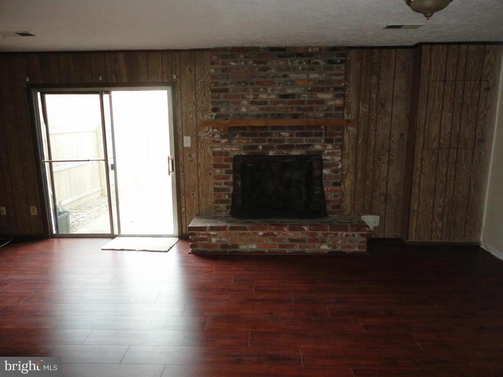 9120 Conservation Way Springfield, VA 22153 - Photo 4 of 19 a view of an empty room with wooden floor and a fireplace