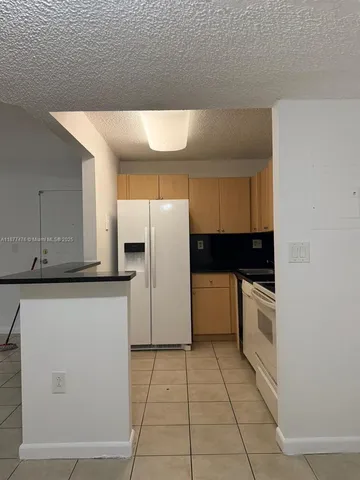 a kitchen with a refrigerator sink and cabinets