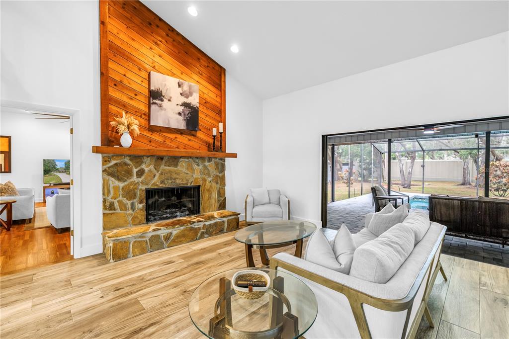 4605 Stone Ridge Trail Sarasota, FL 34232 - Photo 19 of 56 a living room with furniture a fireplace and a floor to ceiling window