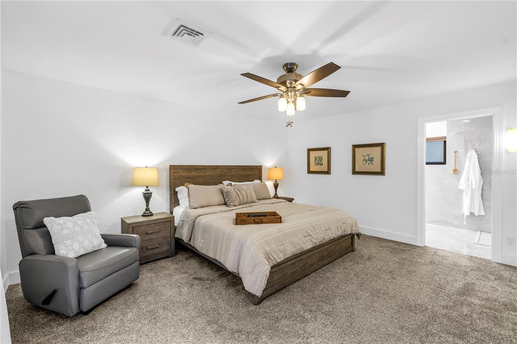 4605 Stone Ridge Trail Sarasota, FL 34232 - Photo 28 of 56 a bedroom with a bed a couch and a chandelier