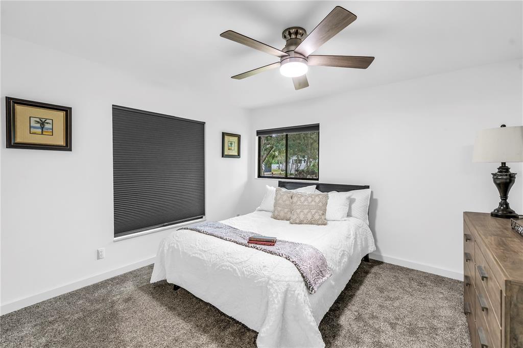 4605 Stone Ridge Trail Sarasota, FL 34232 - Photo 38 of 56 a bedroom with a large bed and a chandelier