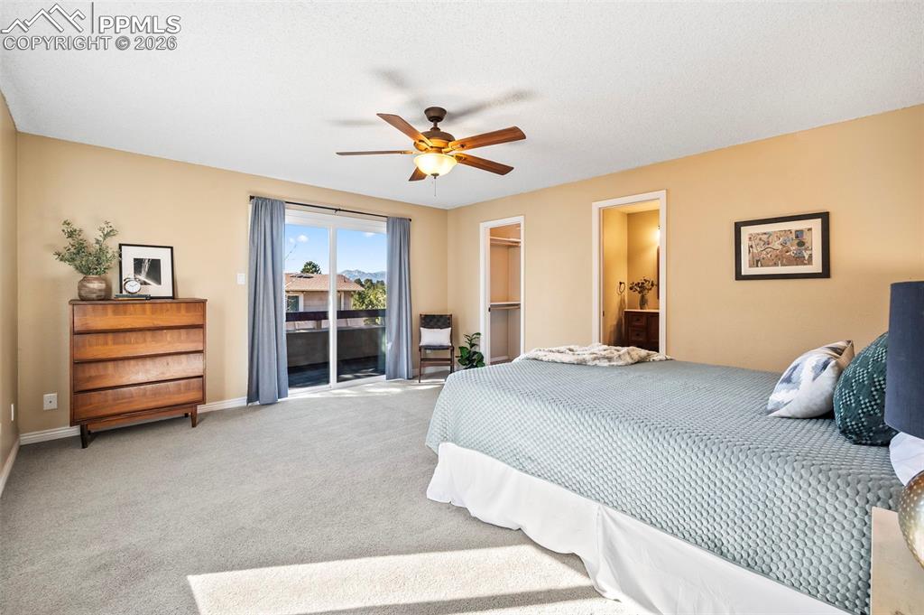1682 Deer Creek Road Monument, CO 80132 - Photo 15 of 39 Primary suite offering a calm, restorative atmosphereand the Private balcony with tranquil views of Pikes Peak + Woodmoor Lake