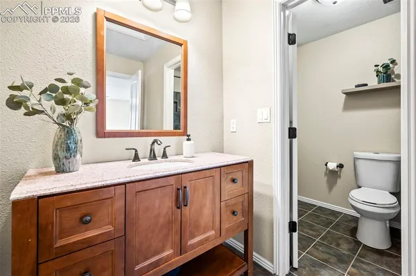 a bathroom with a granite countertop sink mirror and a toilet