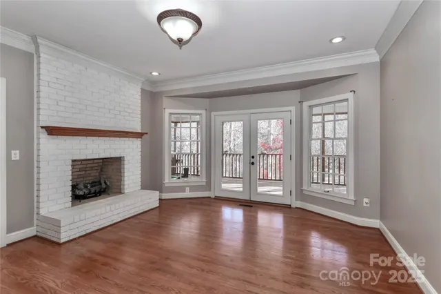 a view of an empty room with exposed radiator and fireplace