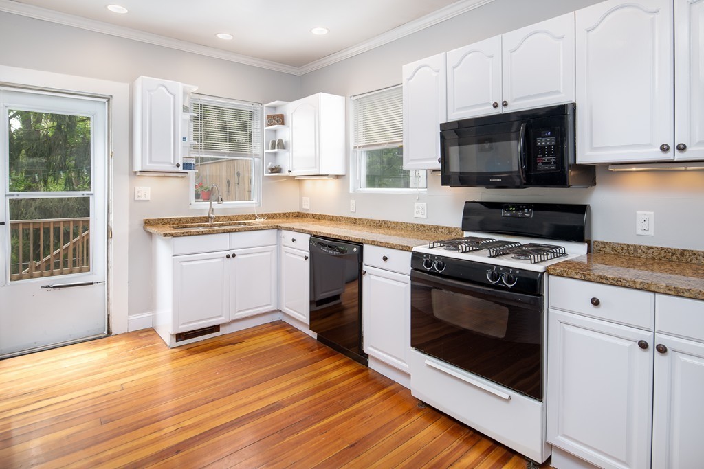 79 Colonial Drive Dedham, MA 02026 - Photo 3 of 12 a kitchen with stainless steel appliances a stove a sink and a microwave