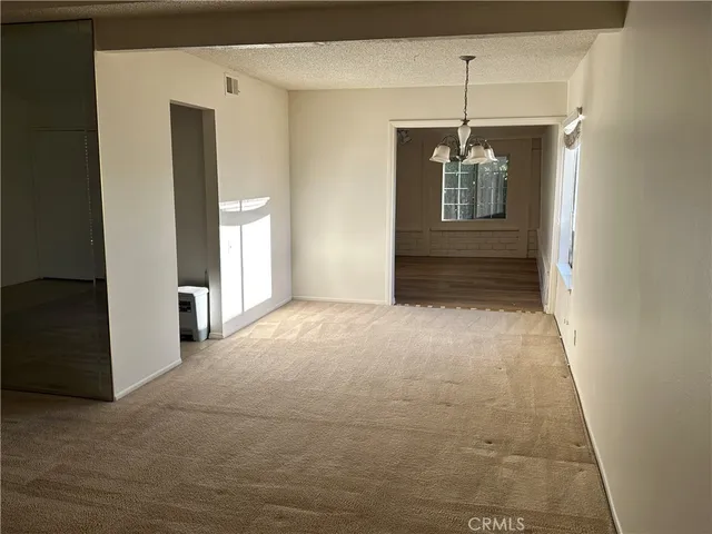 a view of a hallway with closet and chandelier
