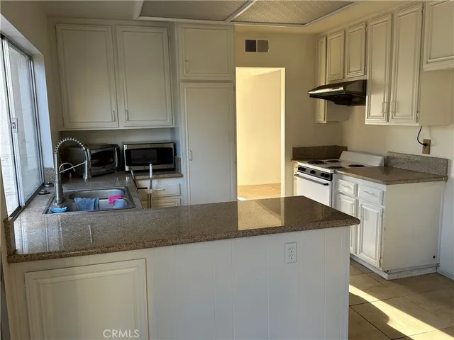 a kitchen with stainless steel appliances granite countertop a sink and a refrigerator
