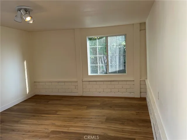 a view of a room with wooden floor and window