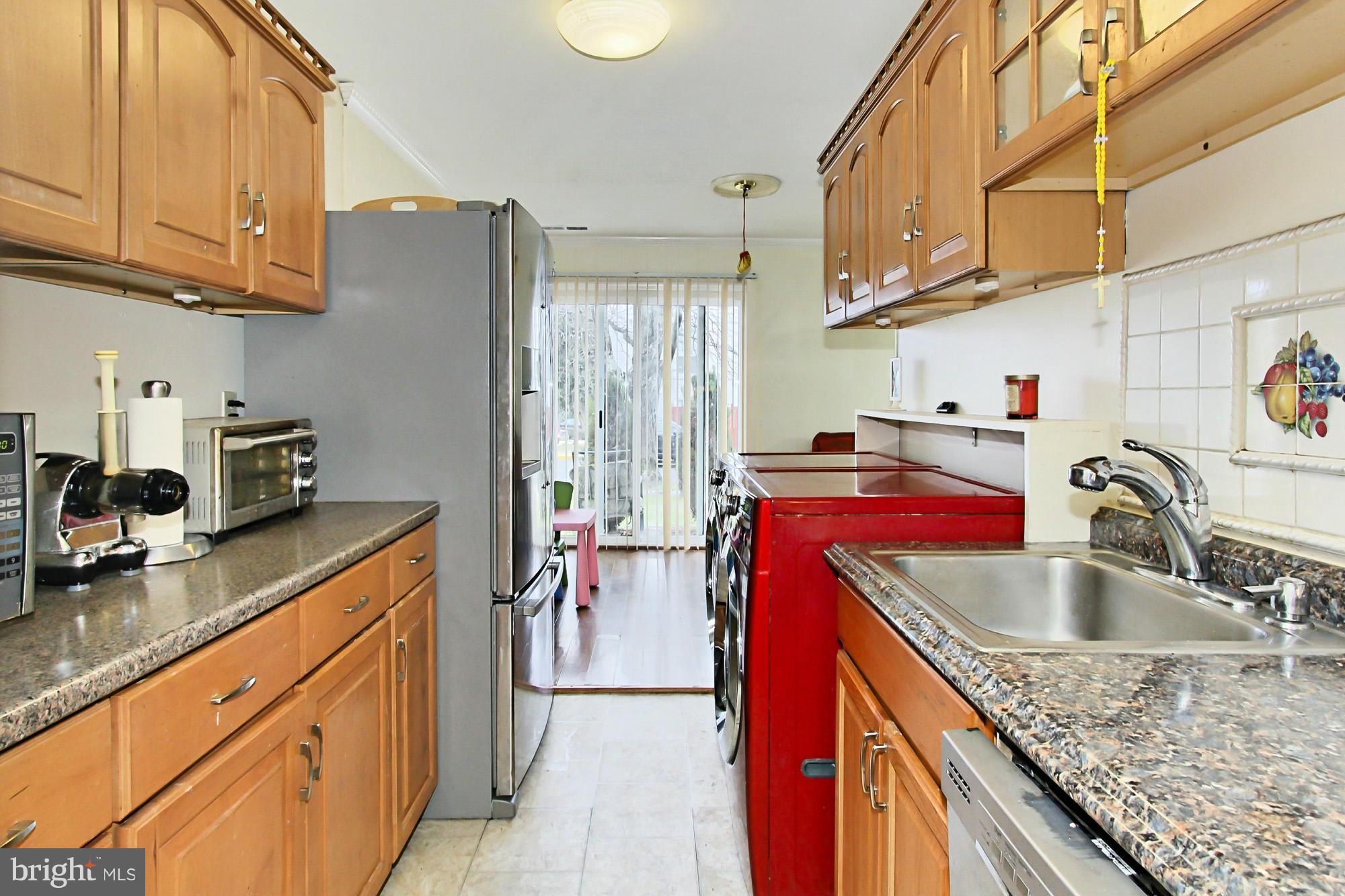 6340 Rockshire Street Alexandria, VA 22315 - Photo 16 of 30 a kitchen with kitchen island granite countertop a sink a counter space and cabinets