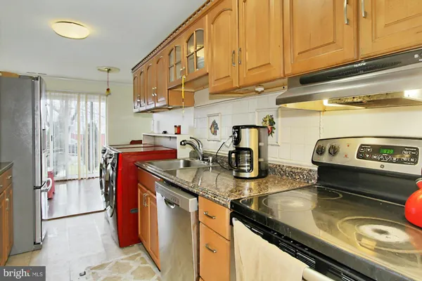 a kitchen with sink a refrigerator and cabinets