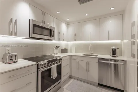 a kitchen with granite countertop cabinets stainless steel appliances and sink