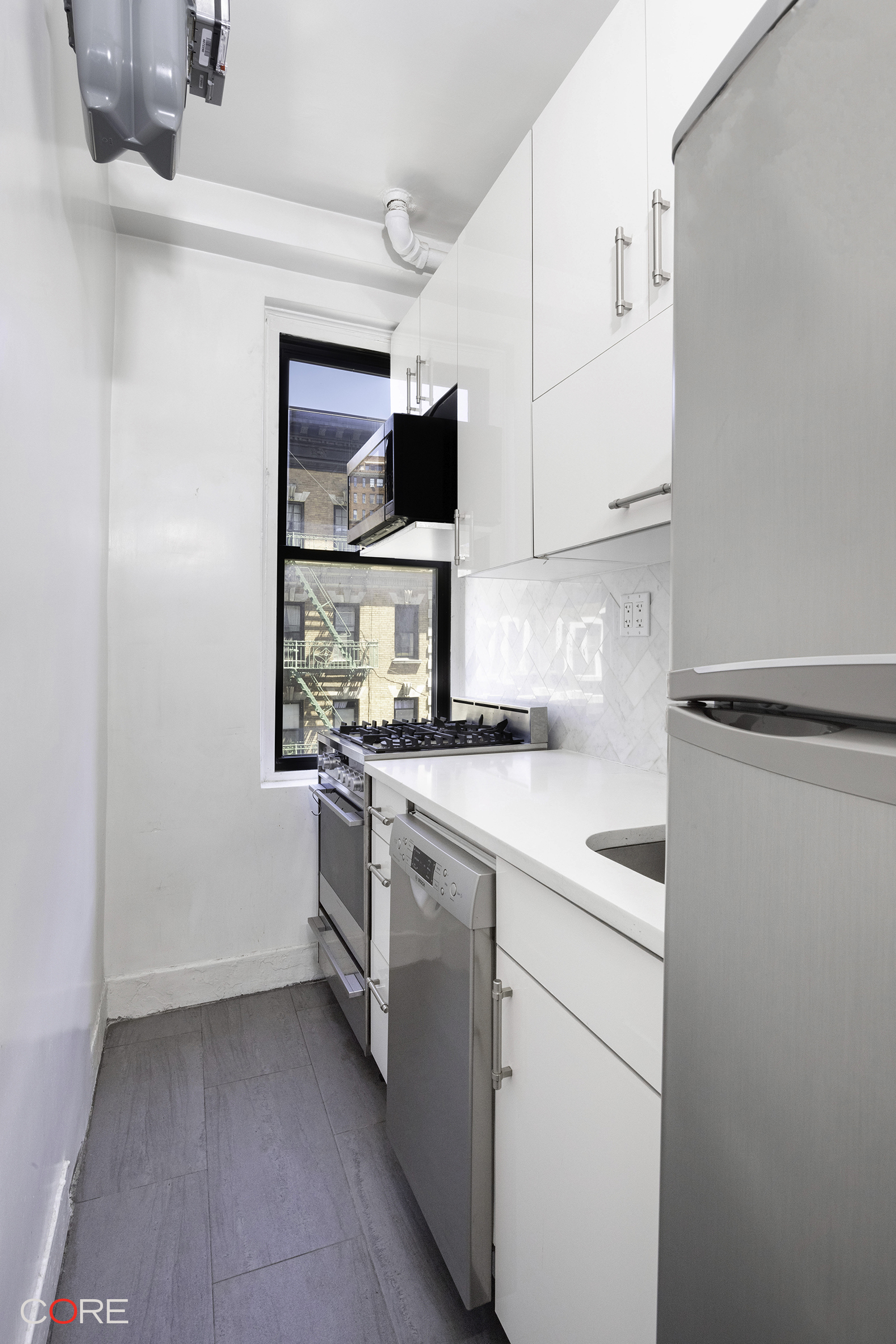 230 West 105th Street, Unit 5AA Manhattan, NY 10025 - Photo 2 of 9 a kitchen with white cabinets and white appliances
