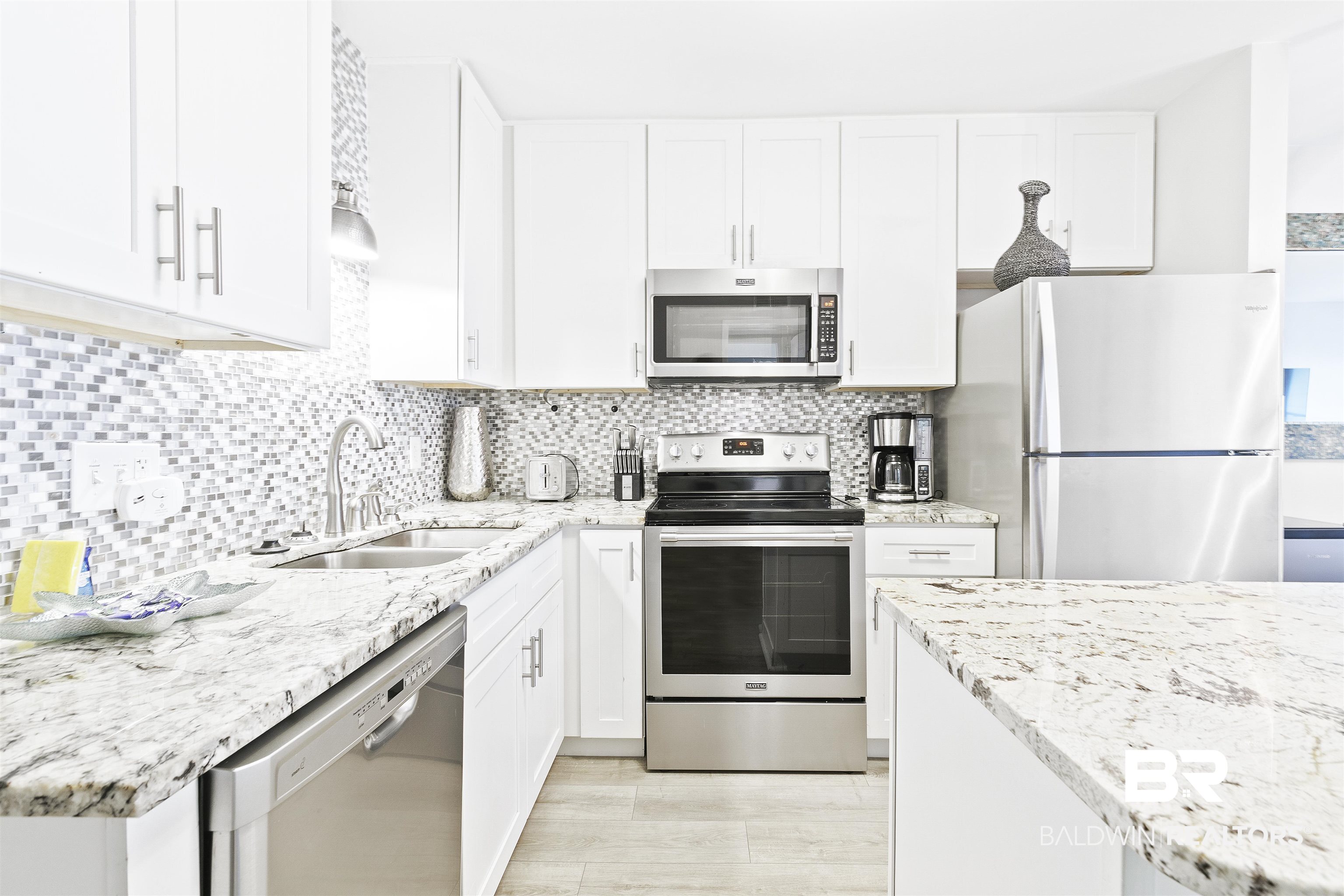 400 Plantation Road, Unit 3314 Gulf Shores, AL 36542 - Photo 12 of 47 Kitchen with tasteful backsplash, sink, white cabinets, and appliances with stainless steel finishes