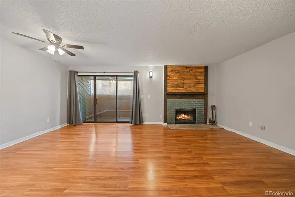 a view of empty room with wooden floor and fireplace