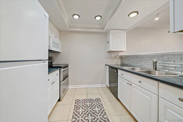 a kitchen with white cabinets and white appliances