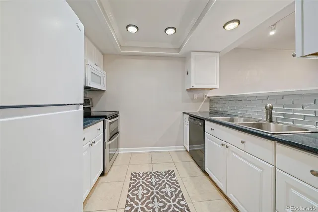 a kitchen with white cabinets and white appliances