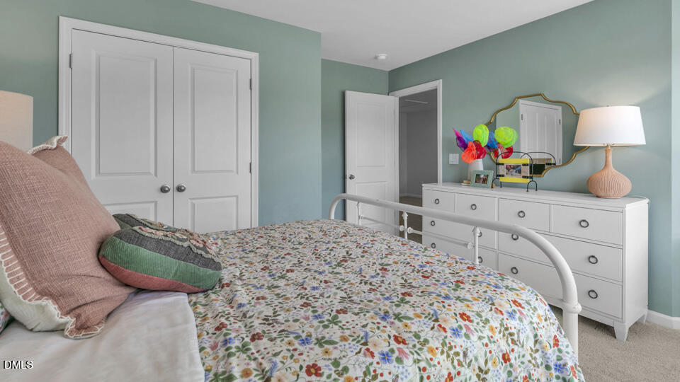 632 Ramo Grande Drive Wake Forest, NC 27587 - Photo 27 of 41 a bedroom with a bed a mirror on dresser and a wooden floor