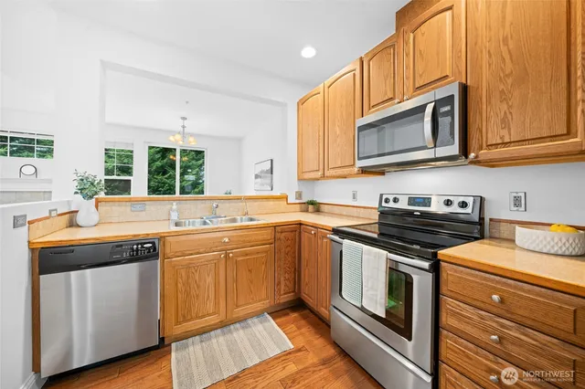 a kitchen with stainless steel appliances granite countertop a stove a sink and a microwave