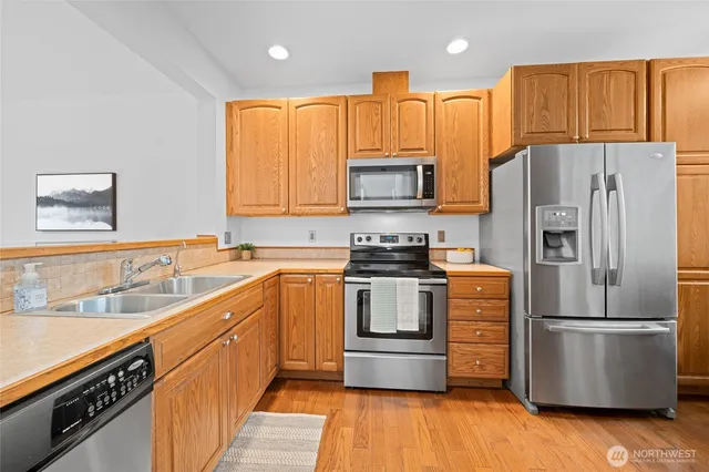 a kitchen with stainless steel appliances a refrigerator sink and microwave