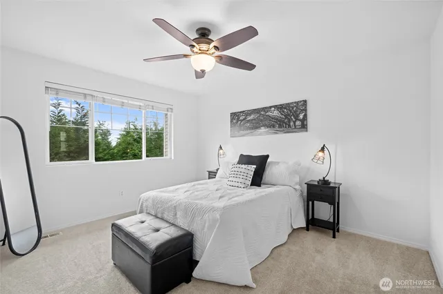 a bedroom with a bed a couch and a window