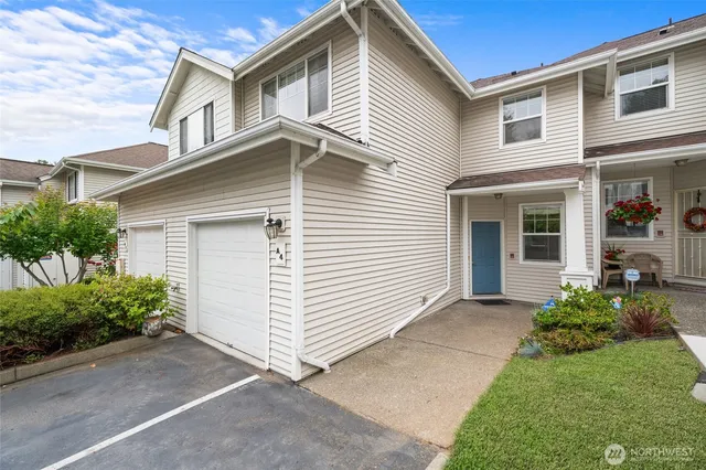 a view of a white house next to a yard