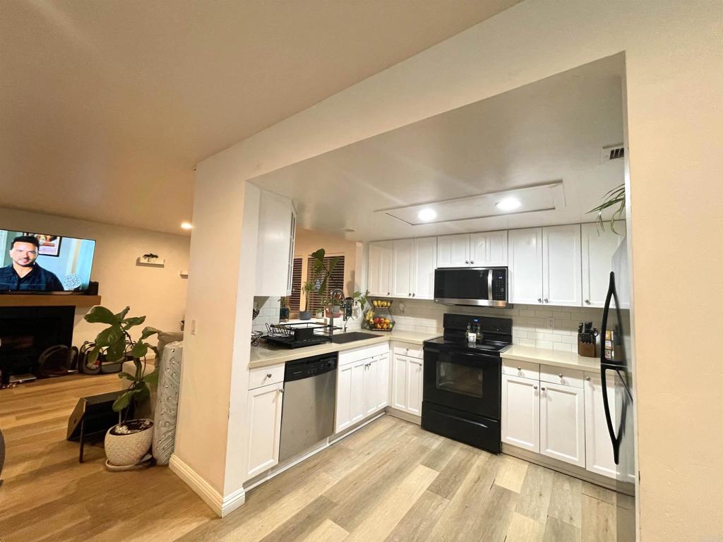 1069 Estes Street El Cajon, CA 92020 - Photo 2 of 41 a kitchen with granite countertop a stove top oven and cabinets