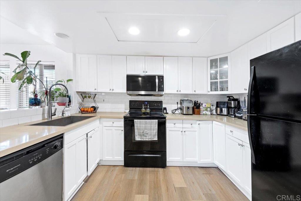 1069 Estes Street El Cajon, CA 92020 - Photo 30 of 35 a kitchen with a sink a microwave a refrigerator and cabinets