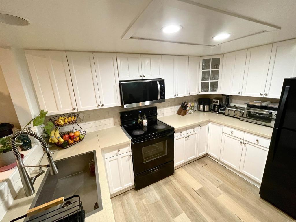1069 Estes Street El Cajon, CA 92020 - Photo 4 of 41 a kitchen with a stove a sink and a microwave