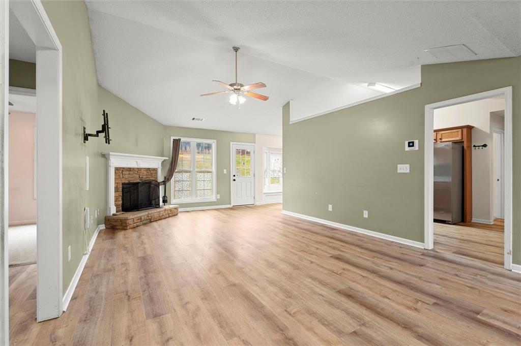 923 Downing Drive Bethlehem, GA 30620 - Photo 3 of 39 an empty room with wooden floor and fireplace