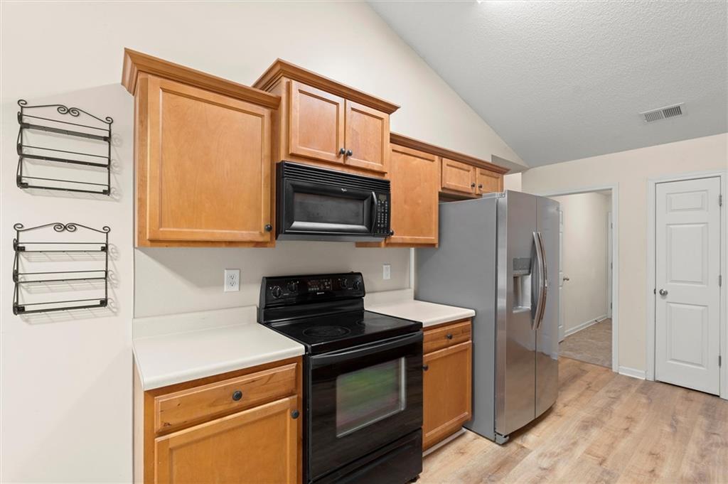 923 Downing Drive Bethlehem, GA 30620 - Photo 9 of 39 a kitchen with stainless steel appliances a stove a microwave and cabinets