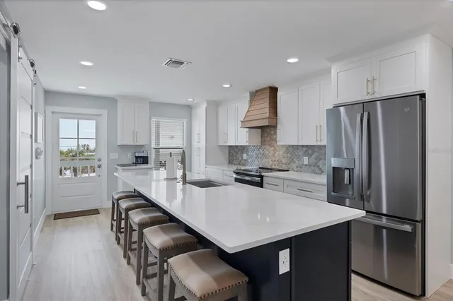a kitchen with refrigerator a sink and chairs