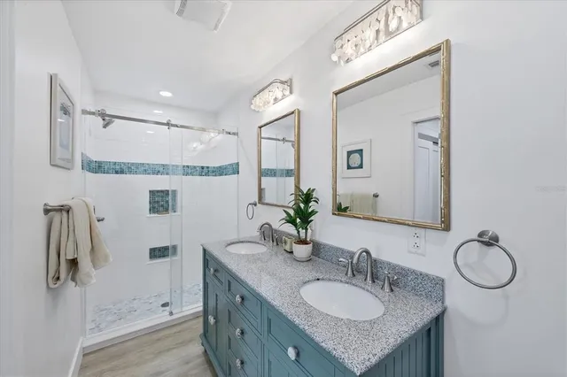 a bathroom with a granite countertop sink a mirror and shower