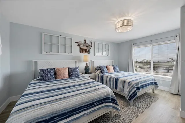 a bedroom with two beds and a large window