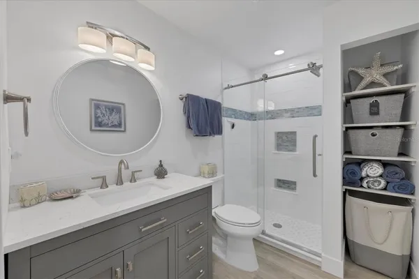 a bathroom with a sink a toilet and shower