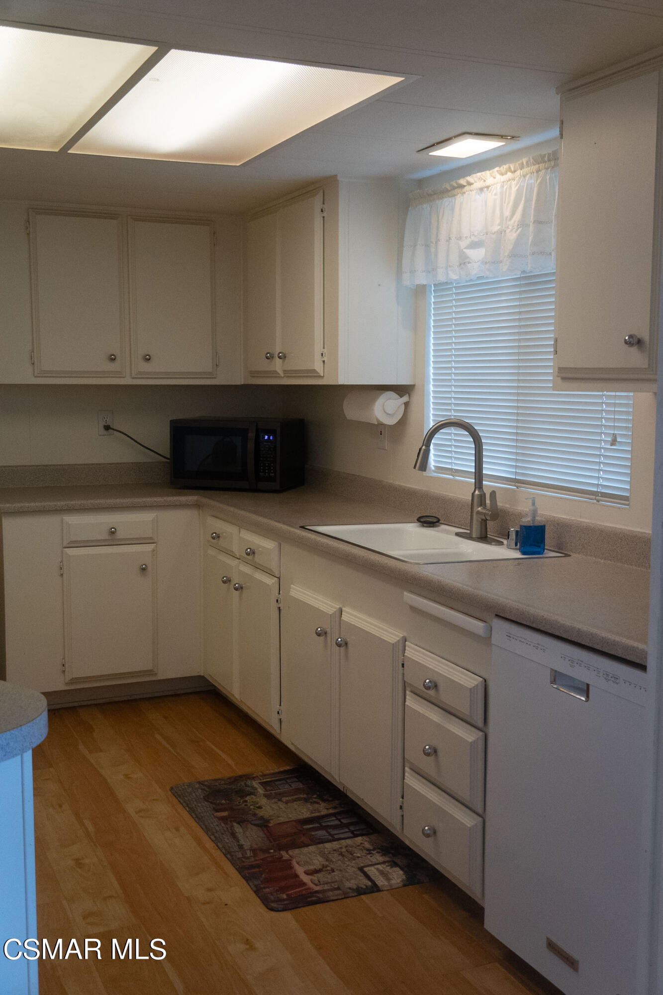 6480 Katherine Road, Unit 65 Simi Valley, CA 93063 - Photo 5 of 20 a kitchen with white cabinets a sink and dishwasher