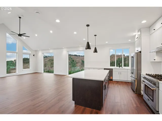 a open kitchen with stainless steel appliances granite countertop a sink a stove and a wooden floors