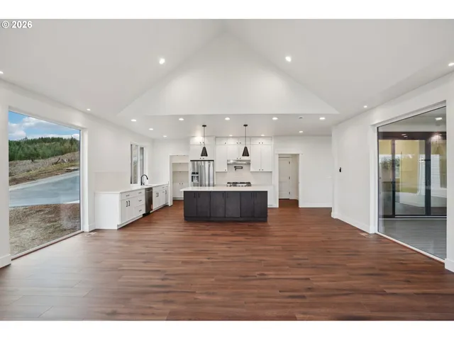 a view of kitchen with kitchen island white cabinets and wooden floor