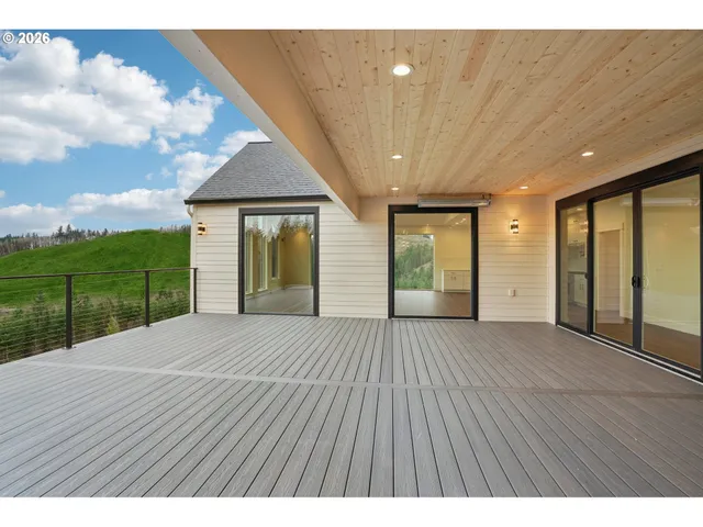a view of an empty room with wooden floor and fence