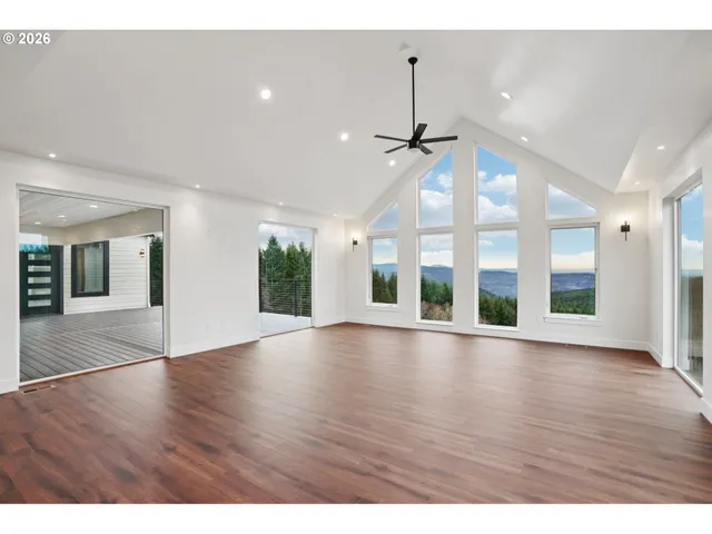 a view of an room with wooden floor chandelier and windows