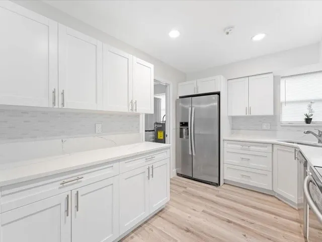 a kitchen with white cabinets and stainless steel appliances
