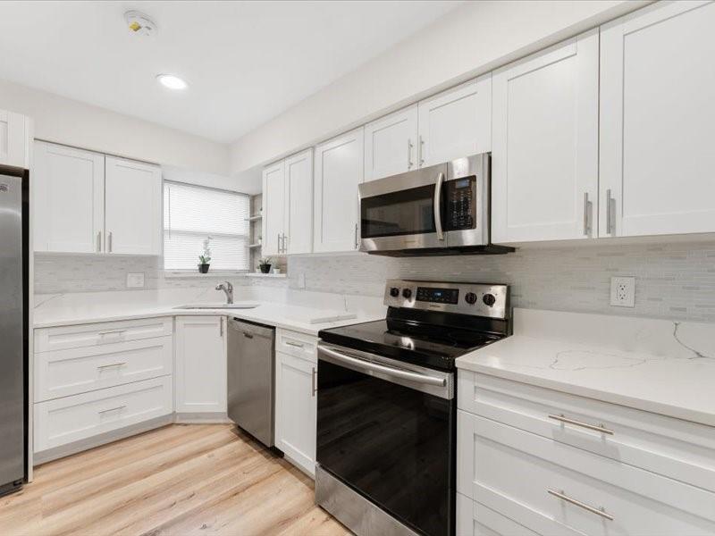 311 West Sample Road Deerfield Beach, FL 33064 - Photo 16 of 34 a kitchen with a sink stove and microwave