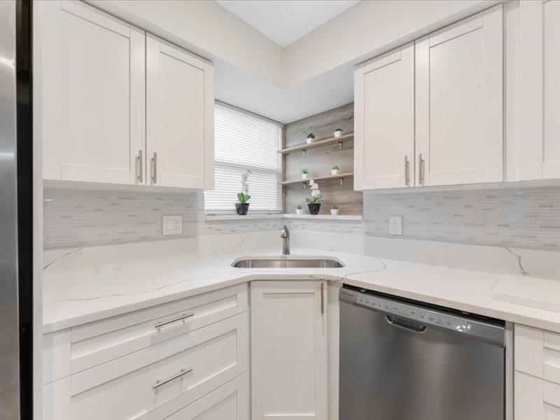 311 West Sample Road Deerfield Beach, FL 33064 - Photo 17 of 34 a kitchen with a sink and cabinets