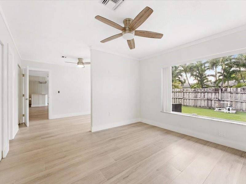 311 West Sample Road Deerfield Beach, FL 33064 - Photo 28 of 34 an empty room with wooden floor fan and windows