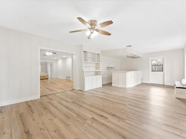 a view of a livingroom with wooden floor and a ceiling fan