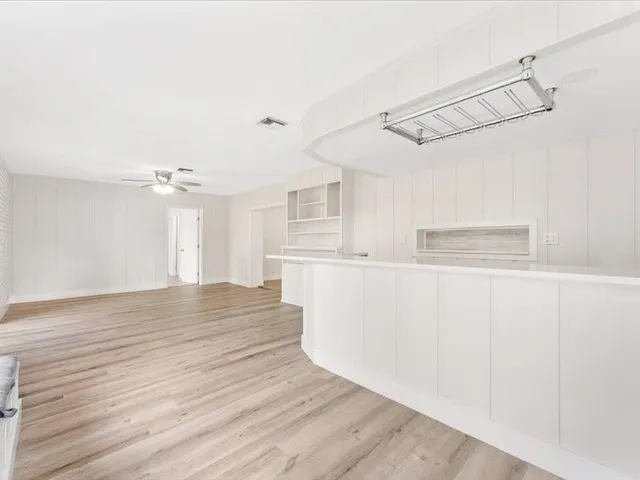 a view of a kitchen with cabinets and wooden floor