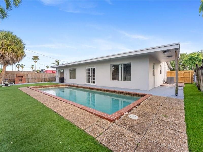 311 West Sample Road Deerfield Beach, FL 33064 - Photo 4 of 34 a view of house with swimming pool and yard